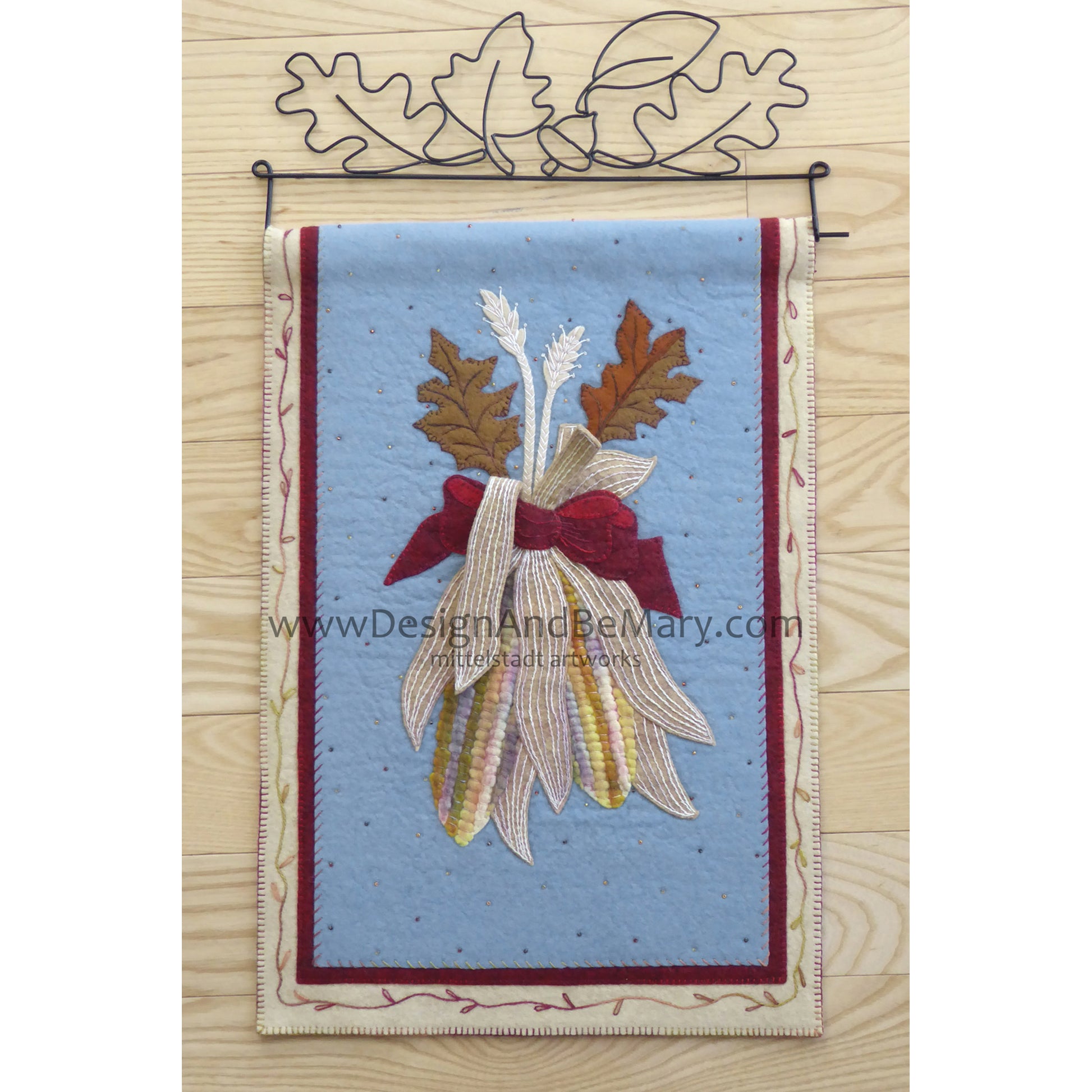 Beautiful mini wall hanging features corn with a couple of leaves bundled together.