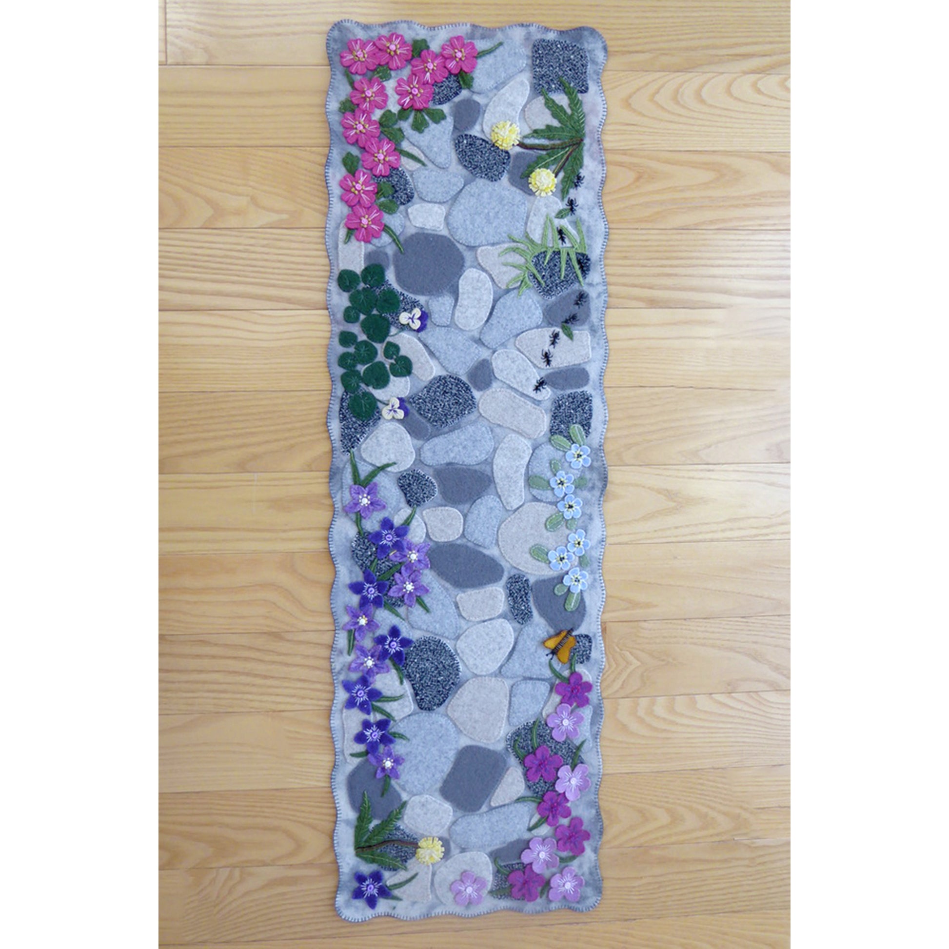 Beautiful, realistic looking garden path table runner. You see flowers peaking over the edge, as well as a few weeds, butterfly and ants. 