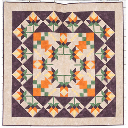 Beautiful quilt features orange flowers in the middle, with a fun pattern for the leaves and in squares around the outside.  Fun for any season.
