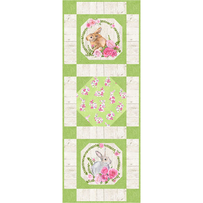 Green and white quilted table runner with bunny and flowers design.