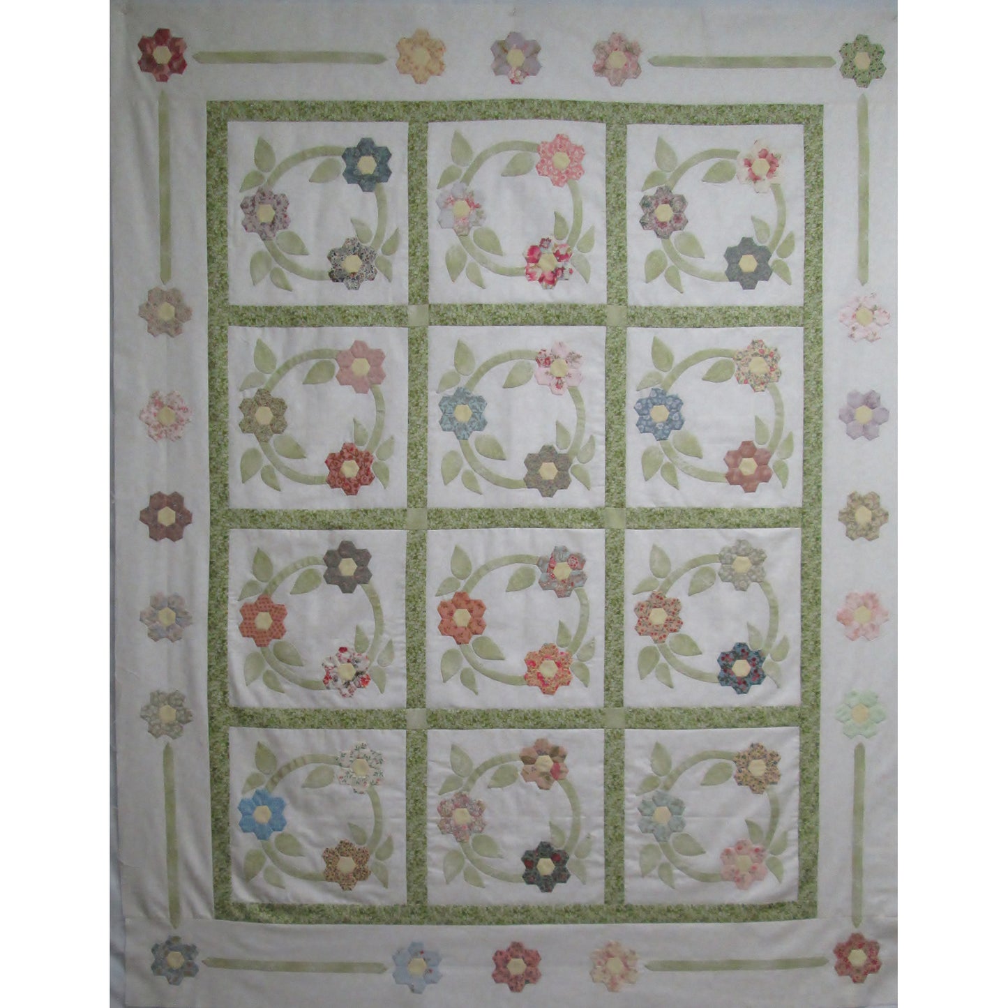 English paper pieced flowers and applique wreaths add a spring feel to any home.