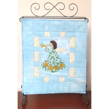 Mini quilt on a stand with angle blowing a horn.
