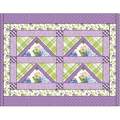 Pretty placemat showcases four flying geese blocks in a rectangle in spring colors and flowers print.