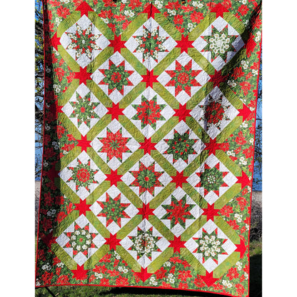 Poinsettia Passion quilt pattern uses Kaleidoscope LeMoyne Stars set on point and sashed with stars for cornerstones.