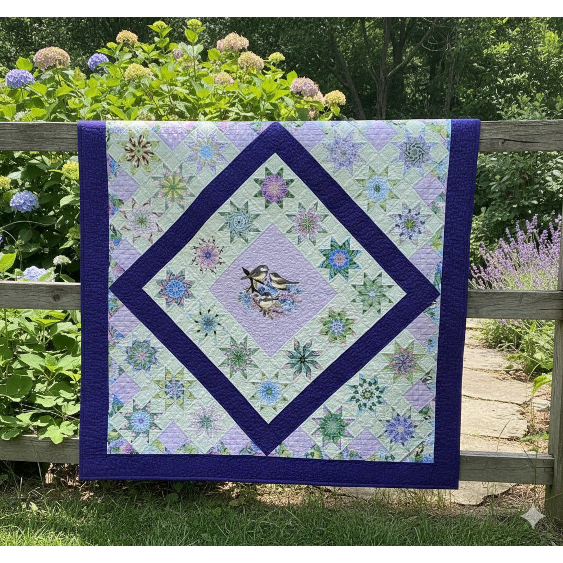 Quilt with floral pattern and bird design on a wooden fence with greenery in the background