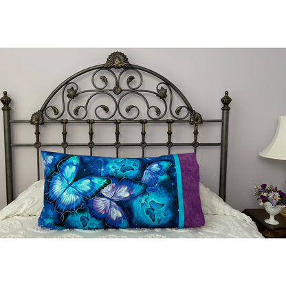 Pillow on a bed with pillowcase showcasing a beautiful blue and purple butterfly fabric.