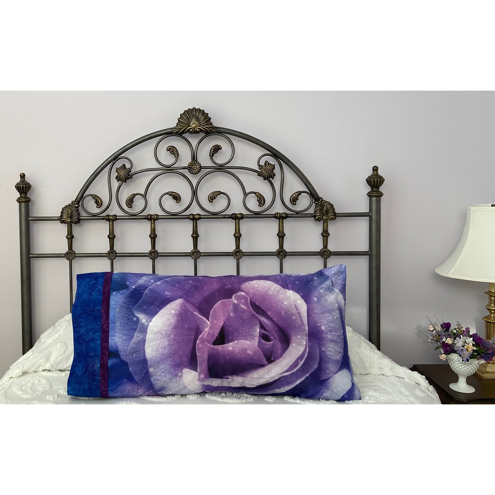 Pillow on a bed with pillowcase showcasing a beautiful purple rose fabric.