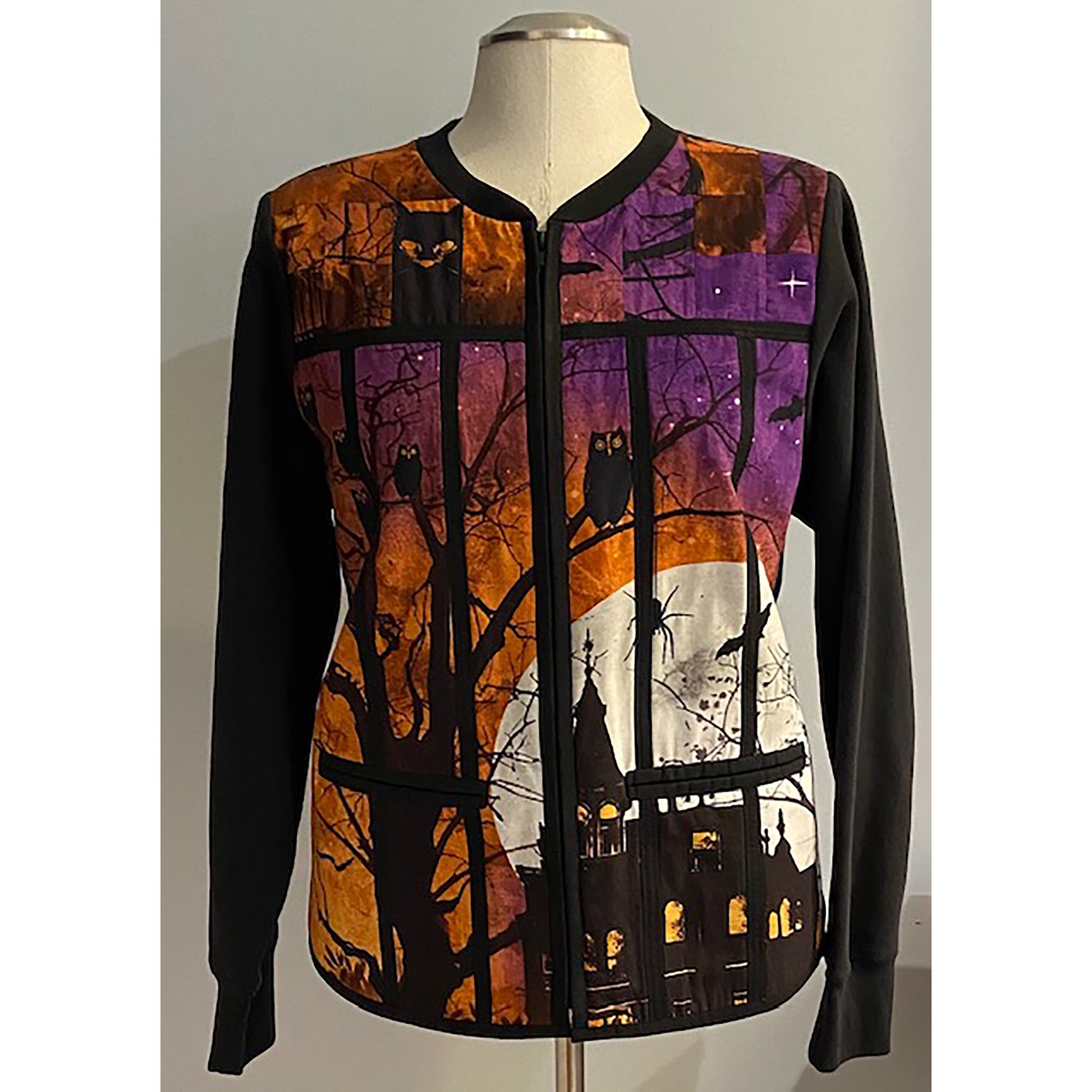 Beautiful jacket with Fall or Halloween fabric in the middle which includes owls and a haunted house with piping in a few places and pockets on either side of the zipper. Solid brown sleeves. 