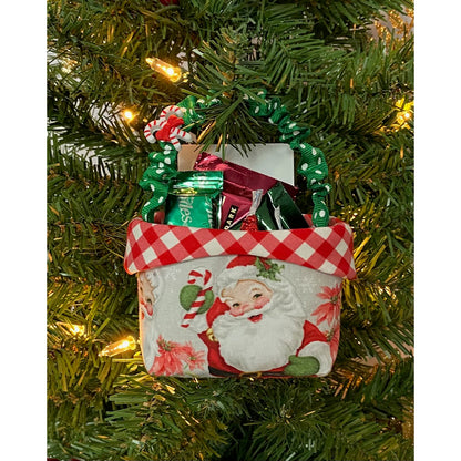 Adorable basket hanging in a Christmas tree. Basket includes a handle which is used to hang the basket in the branches. Basket is filled with mini candies and has a Santa design in fabric.