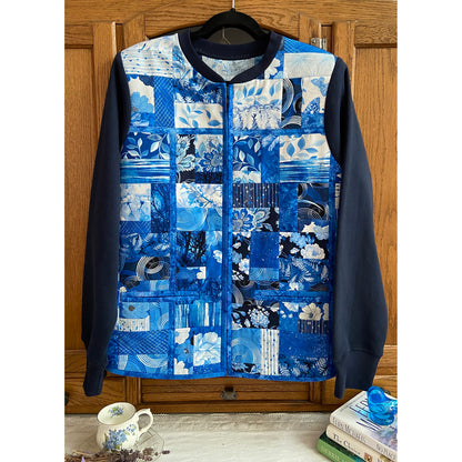 Beautiful jacket has a patchwork of fabric squares and rectangles in shades of blue and white. Very elegant looking.