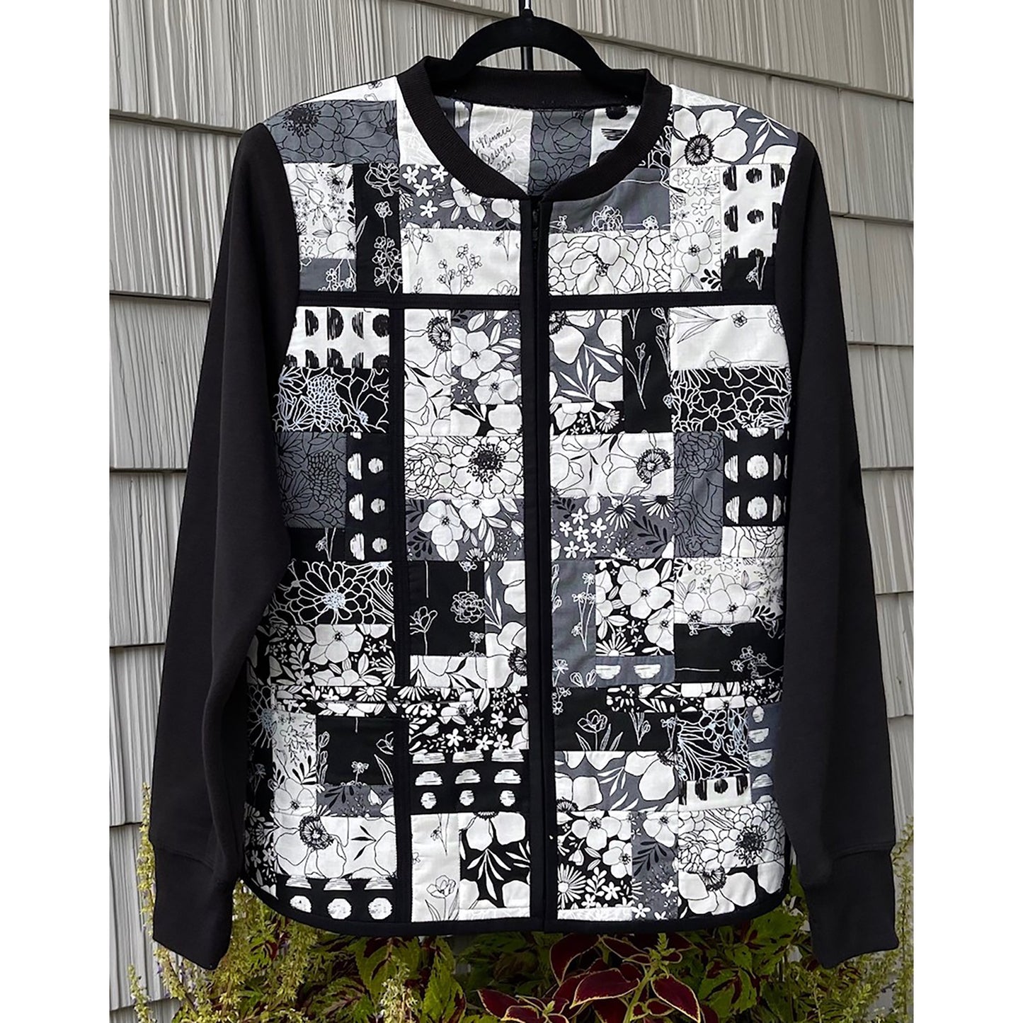 Beautiful jacket has a patchwork of fabric squares and rectangles in black and white. It will go with almost anything!