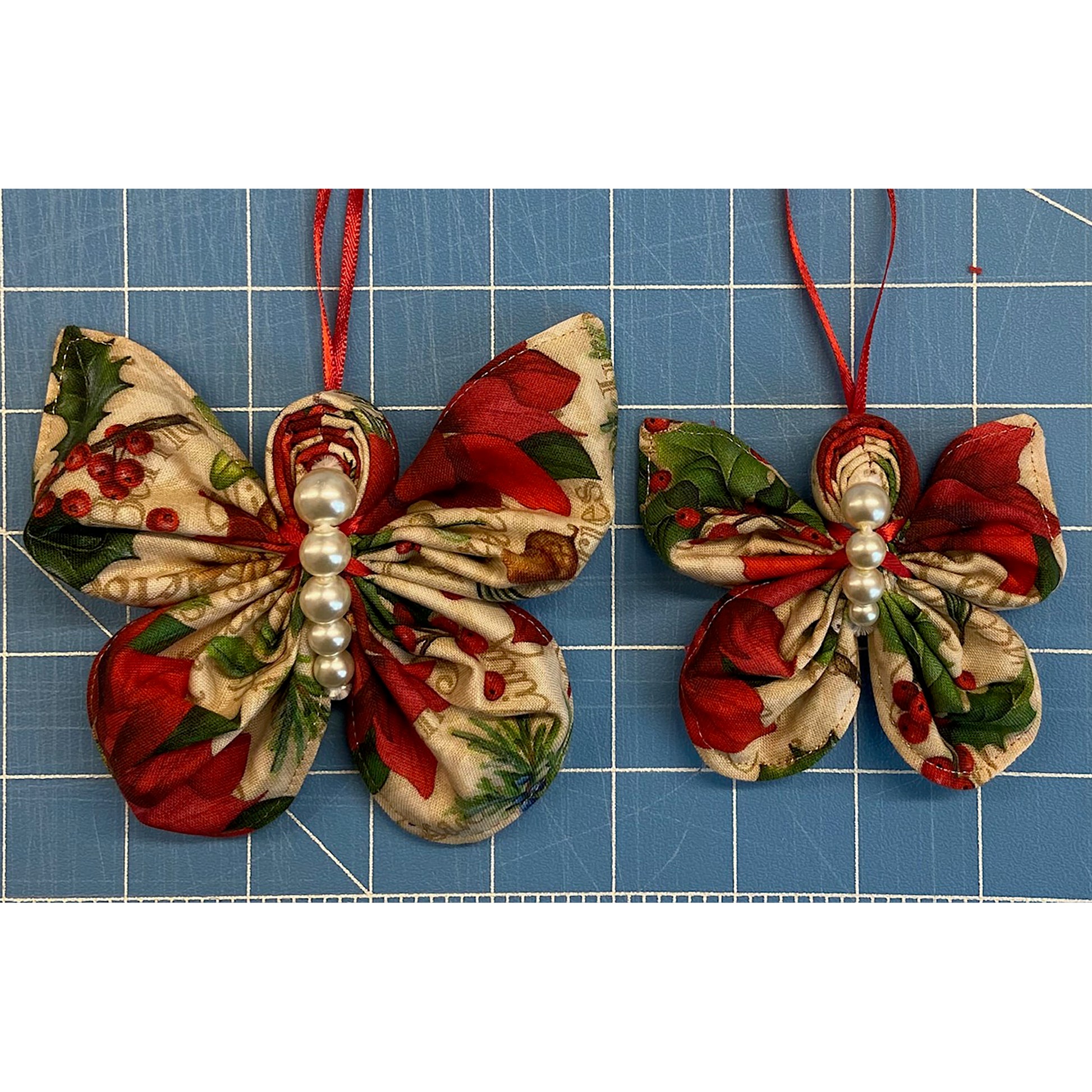 Two beautiful Christmas colored with gold fabric butterfly ornaments. One is slightly smaller than the other. Includes beads in the middle for the butterfly body. The colors make them look more classic.