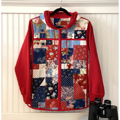 Beautiful quilted jacket in bed with patchwork looking front in red, white and blue fabric.