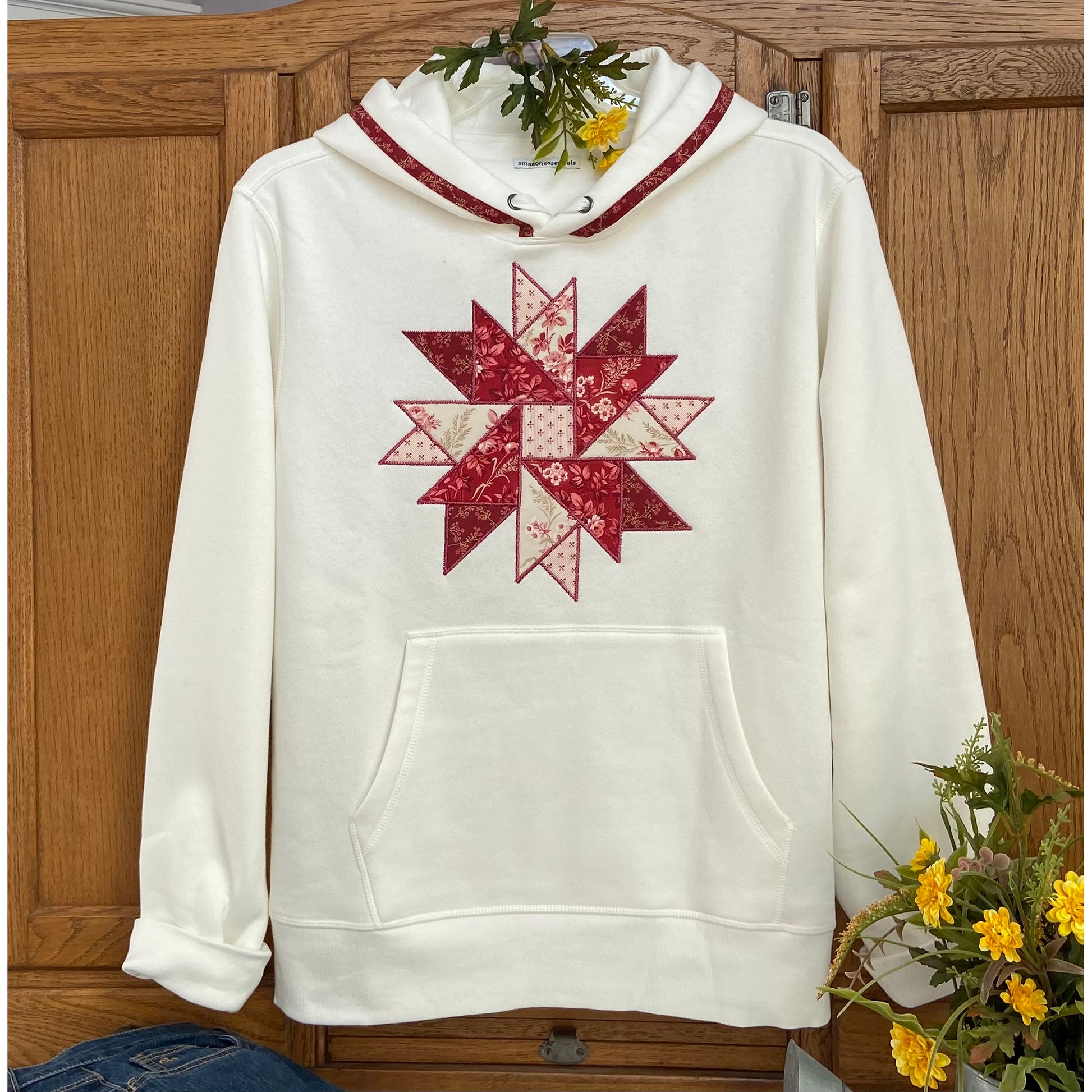 Beautiful star block in red and pink on a white sweatshirt.