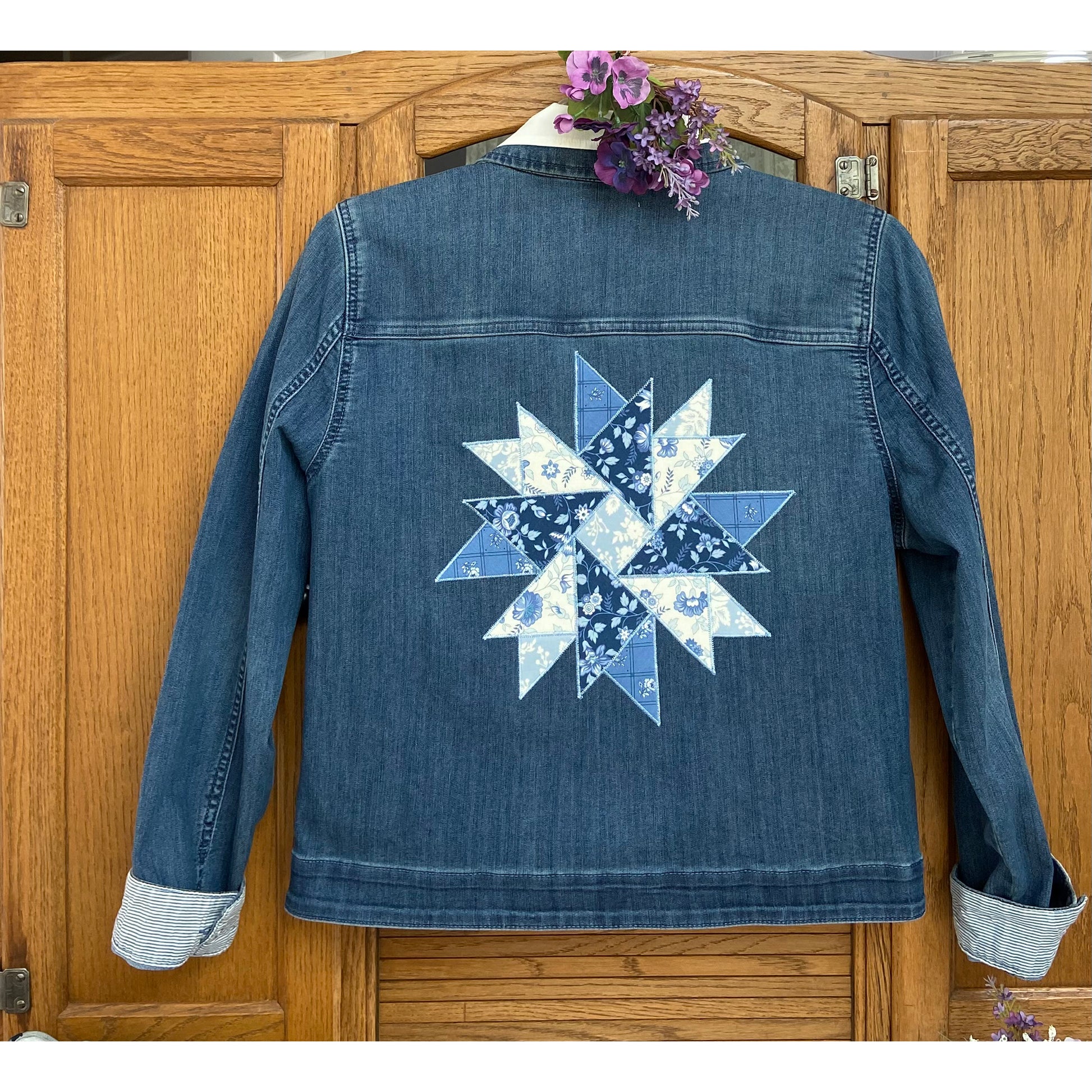 Back of a jean jacket with a beautiful star made of blue and white fabric.