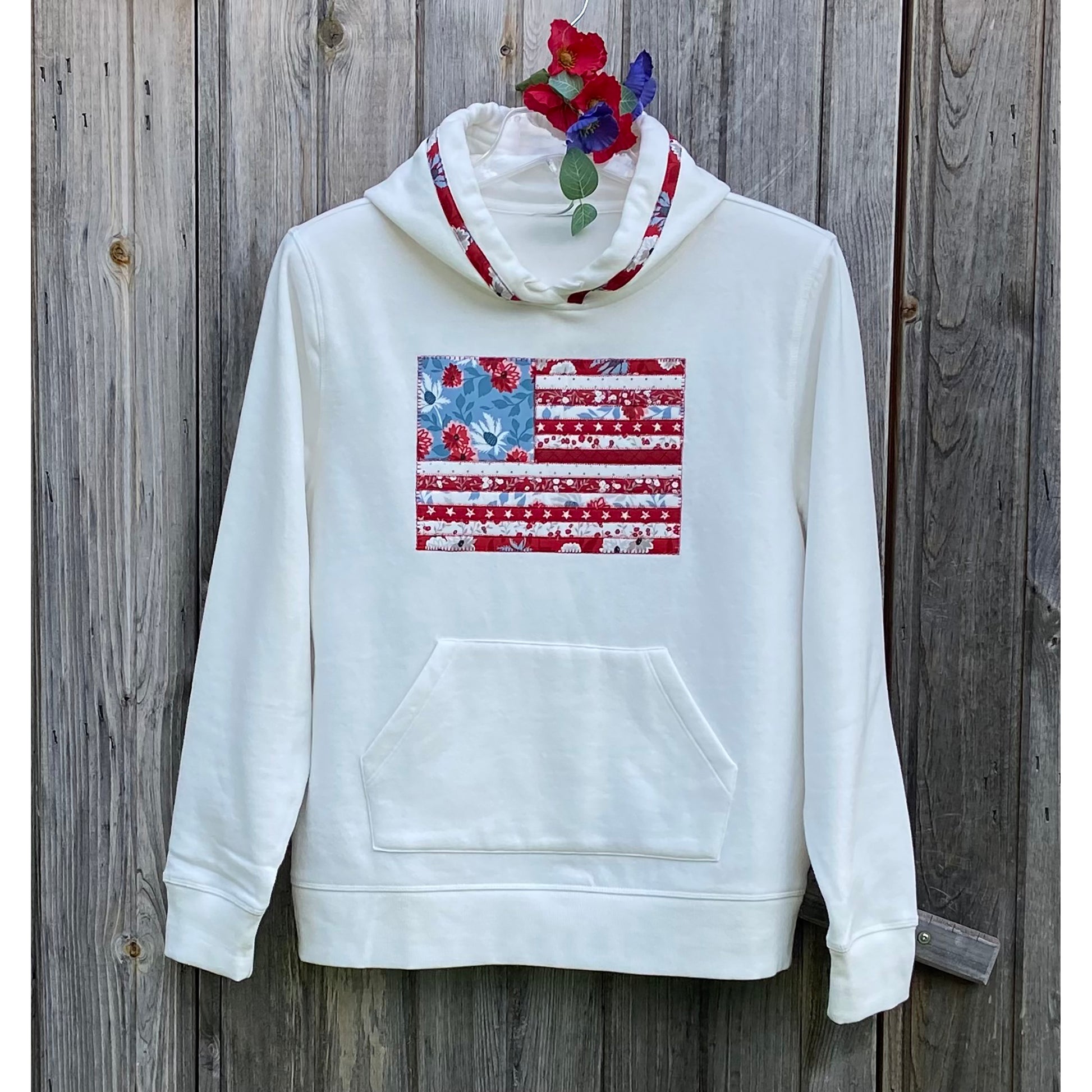 White hoodie sweatshirt with red, white and blue American flag with flower fabric in the middle.