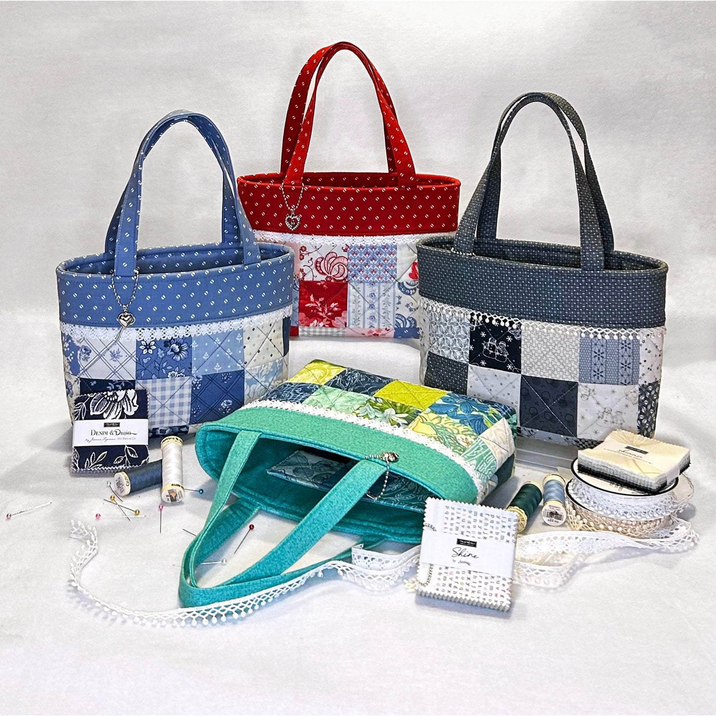 This is the cutest little tote bag using a mini charm pack!  Four are shown with some notions to show how big it is.