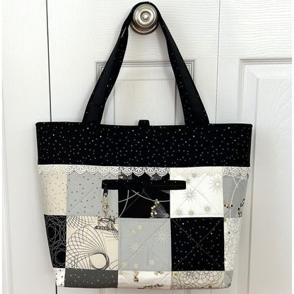 Adorable tote bag using a Charm Pack. It has a back zippered pocket to hold all your treasures. Shown with neutral colors and cute little zippered pocket with a swing charm hanging off the zipper end.