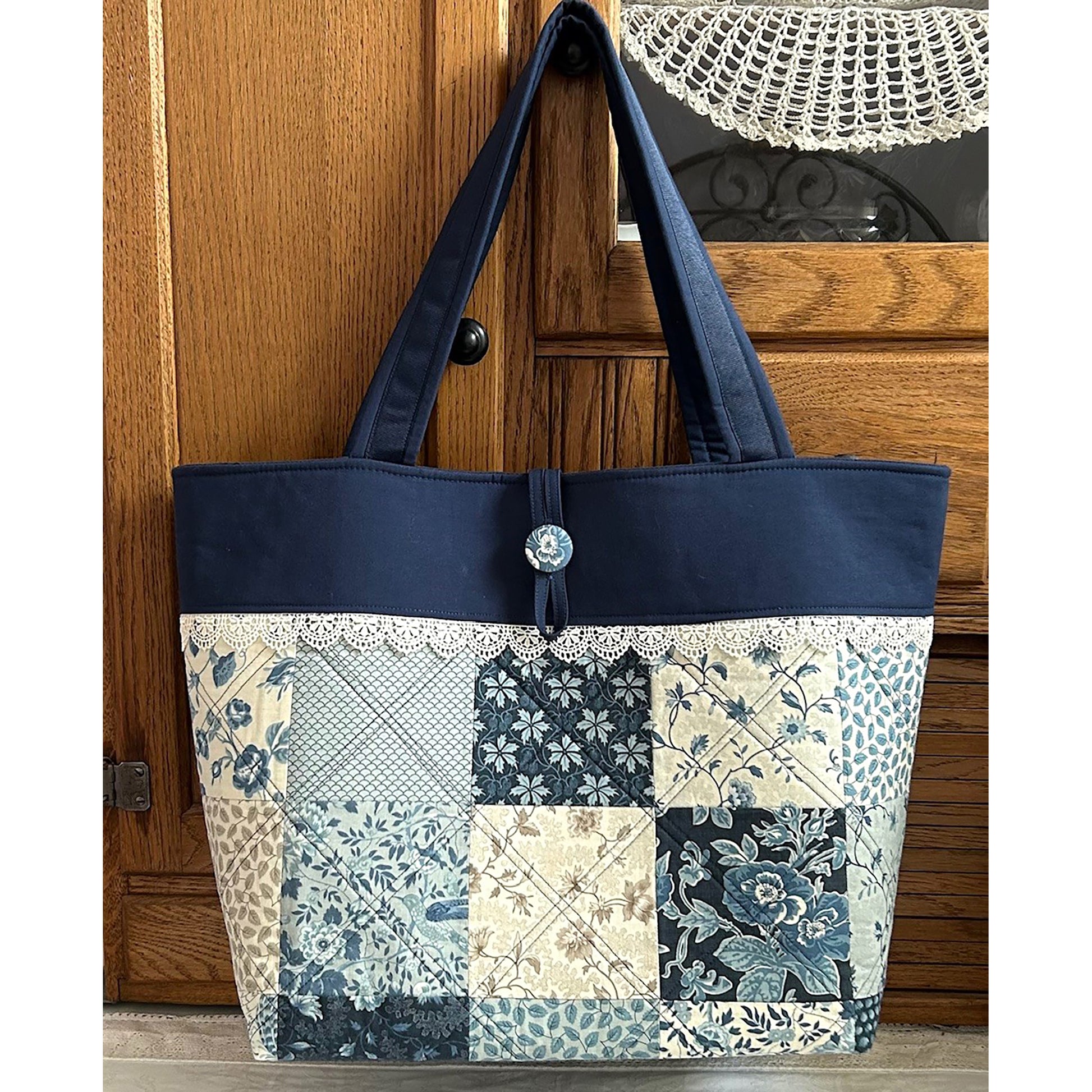 Adorable tote bag using a Charm Pack. It has a back zippered pocket to hold all your treasures. Fabrics in blues.