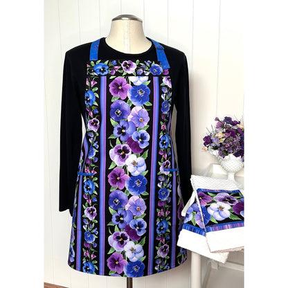 A one-of a kind apron using border stripe fabric. The apron is fully lined with pocket options. Make coordinating kitchen towels from leftover scraps.  Image shows the one in pansies print.
