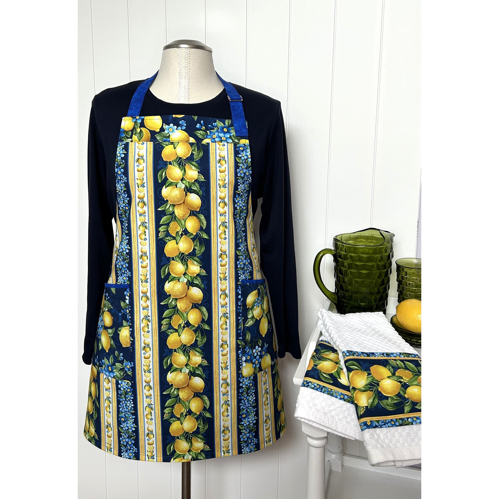A one-of a kind apron using border stripe fabric. The apron is fully lined with pocket options. Make coordinating kitchen towels from leftover scraps.  Image shows the one in lemons print.