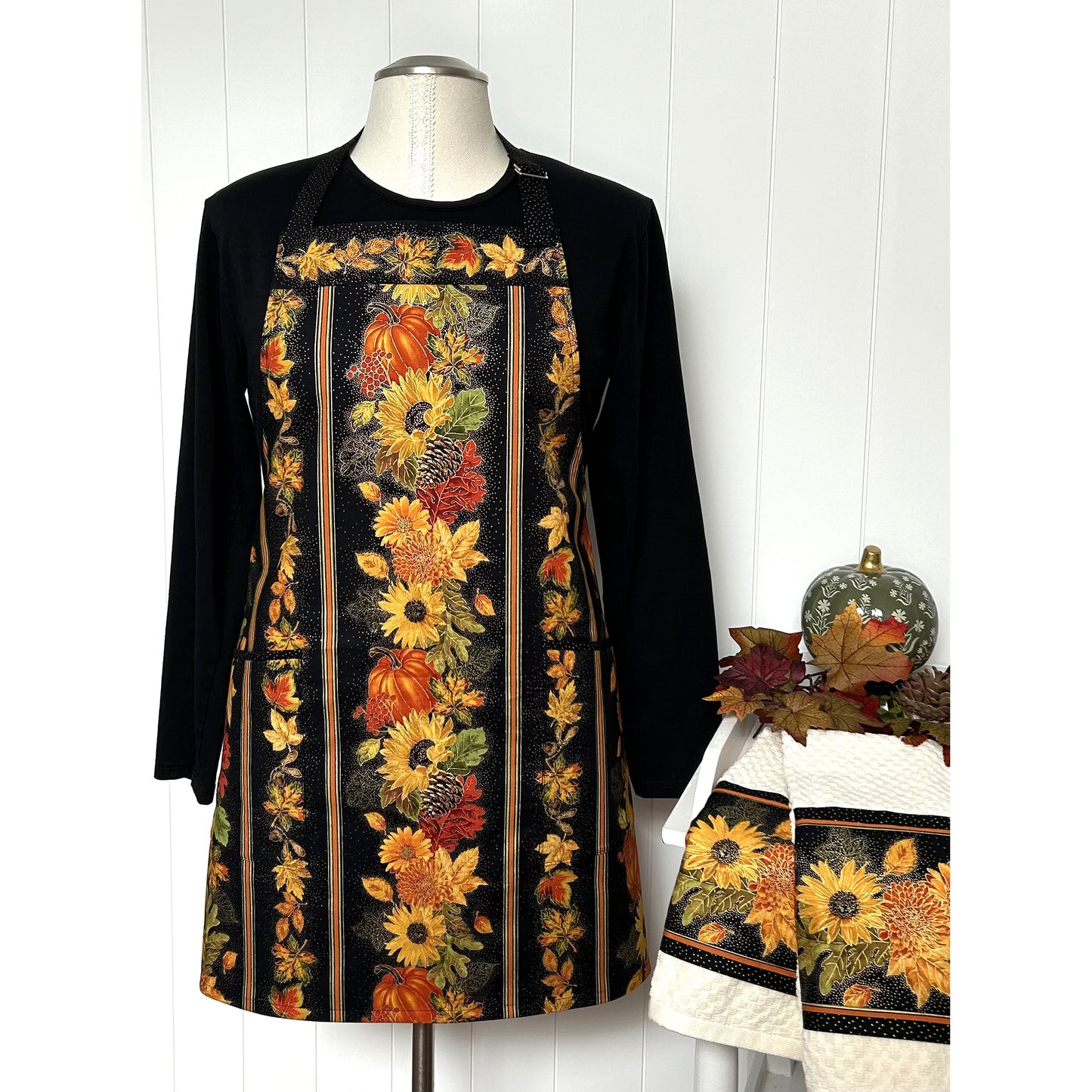 A one-of a kind apron using border stripe fabric. The apron is fully lined with pocket options. Make coordinating kitchen towels from leftover scraps.  Image shows the one in sun flowers and pumpkins print.