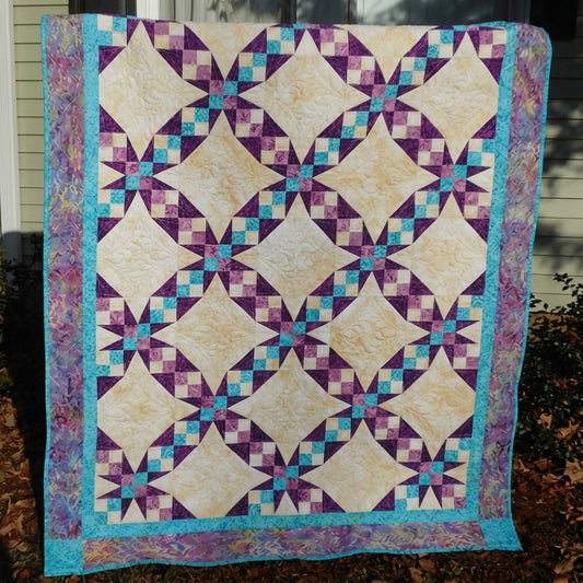 Island Waltz quilt was inspired by the traditional Tennessee Waltz Pattern. It includes diagonal four-patches in what looks like ribbons between. At the connecting points are Ohio Star blocks.  Lots to see and only 3 colors.