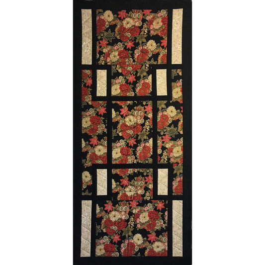 Black and red floral quilt with black and white trim, perfect as a wall hanging.