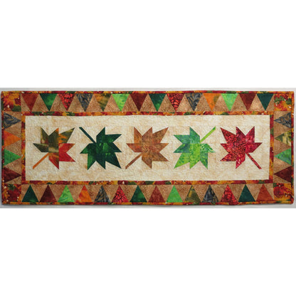 Autumn table runner with falling maple leaves down the middle.