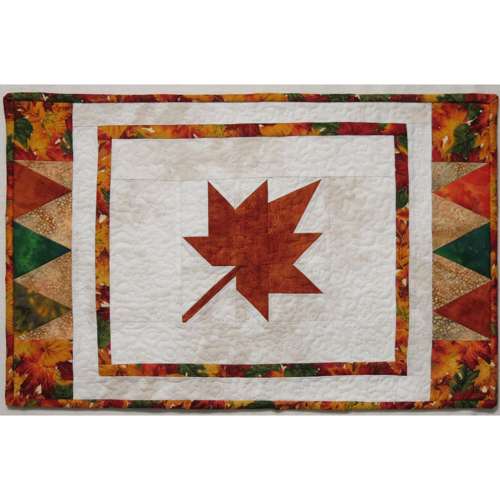 Placemat with an orange/red maple leaf in the middle.