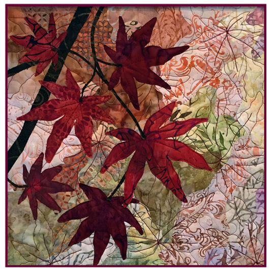 Vibrant fall quilt features overlapping maple leaves in fall colors on a tree branch.