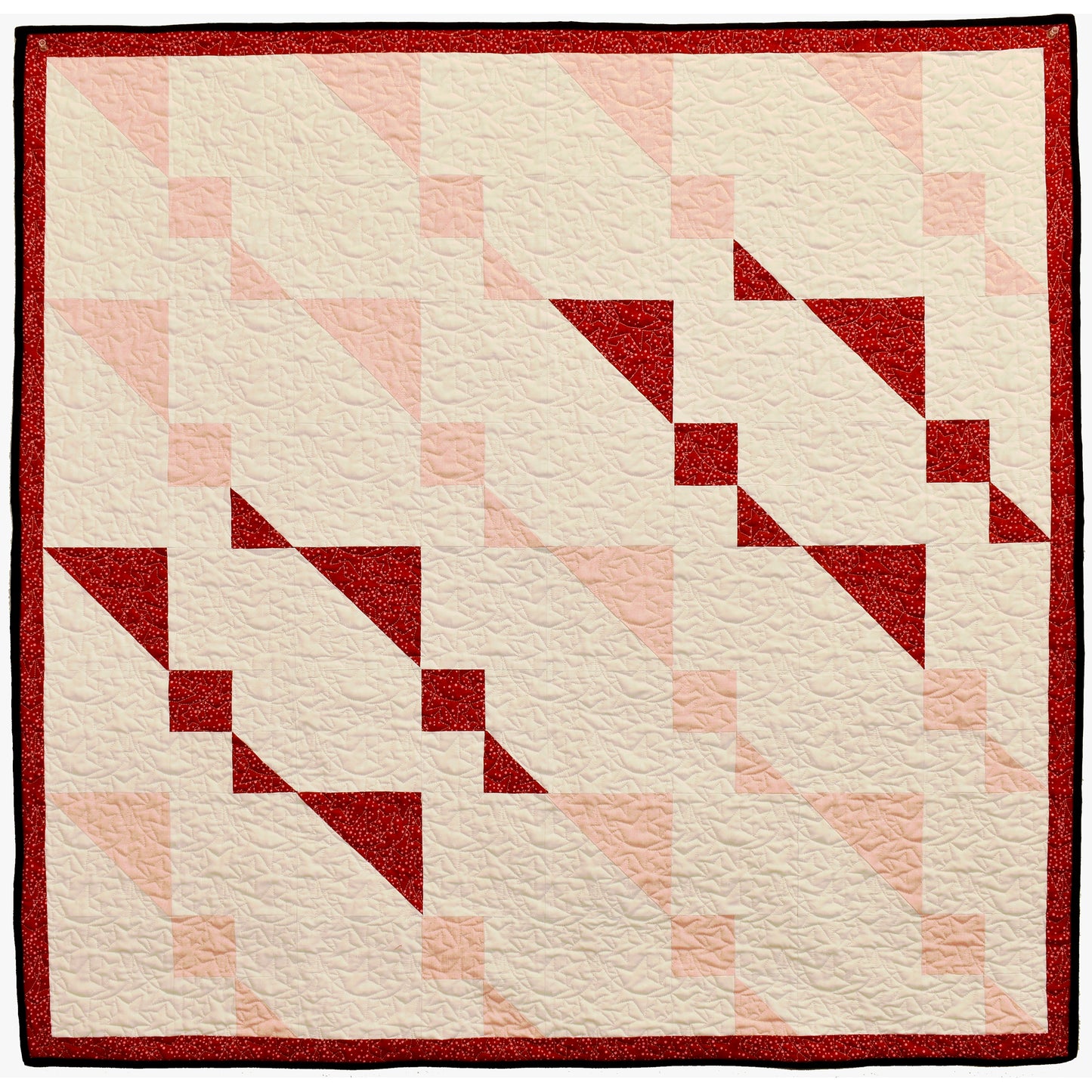 Twin Sisters quilt sparkles with holiday shimmer. The wall hanging features twin, abstract stars with others in light colors.