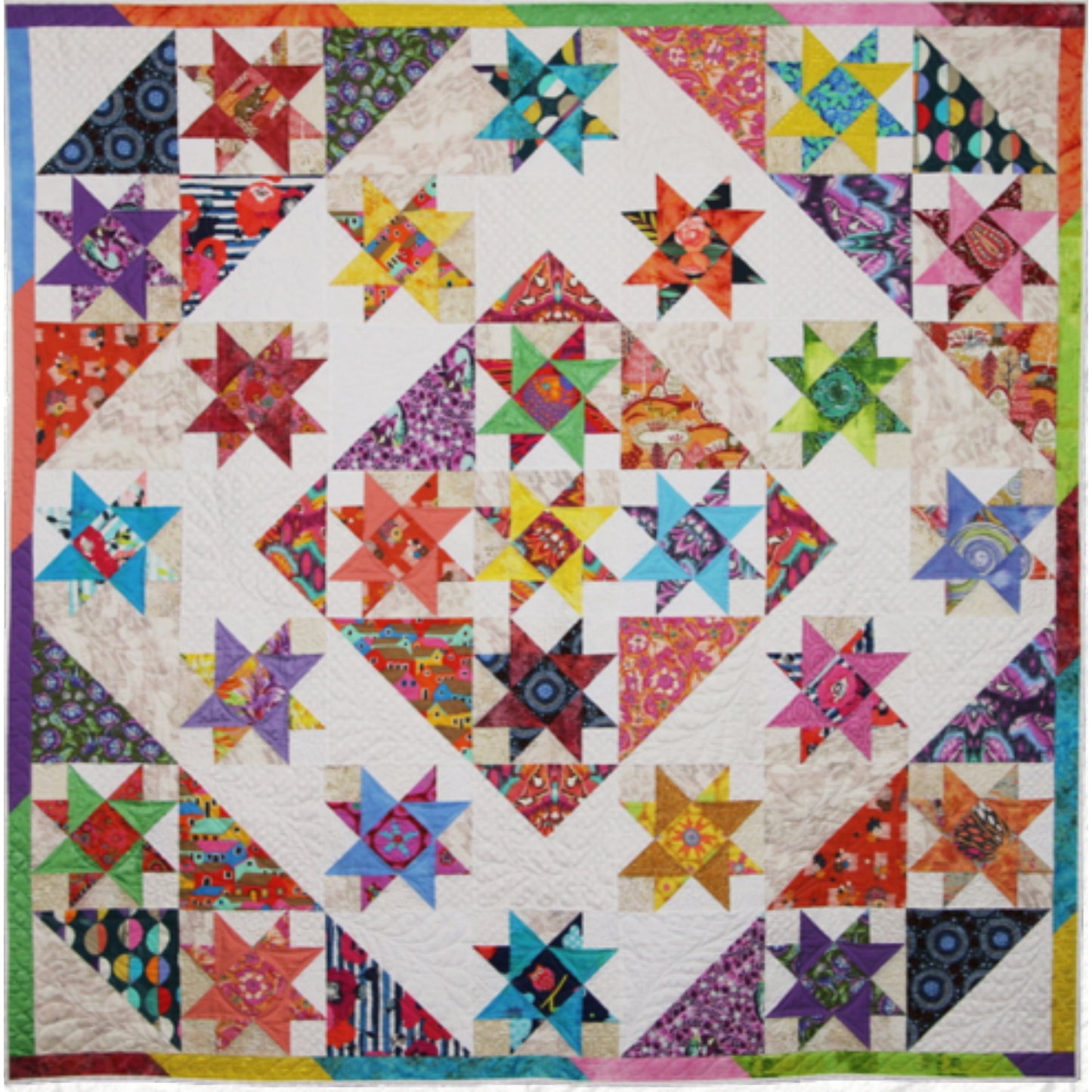 Colorful quilt features lots of fabrics and colors of stars with a middle diamond of stars, an outside diamond with a neutral background for the stars and corners of stars.
