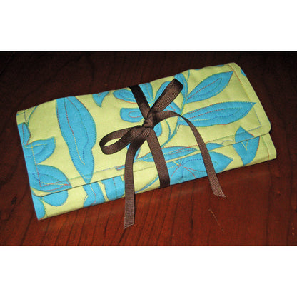 Roll & Go Sewing Organizer shown rolled up with a ribbon to keep it closed.