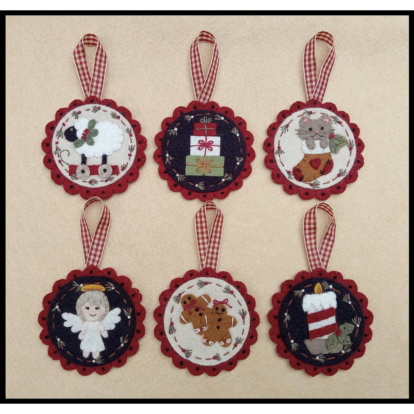 Six adorable and festive Christmas ornaments have applique designs to make each unique. They are round with scalloped edge and ribbon hanging from the top. The six designs include: sheep toy on wheels, stack of presents, cat in a stocking, angle, two gingerbread people, and candle with some holly.