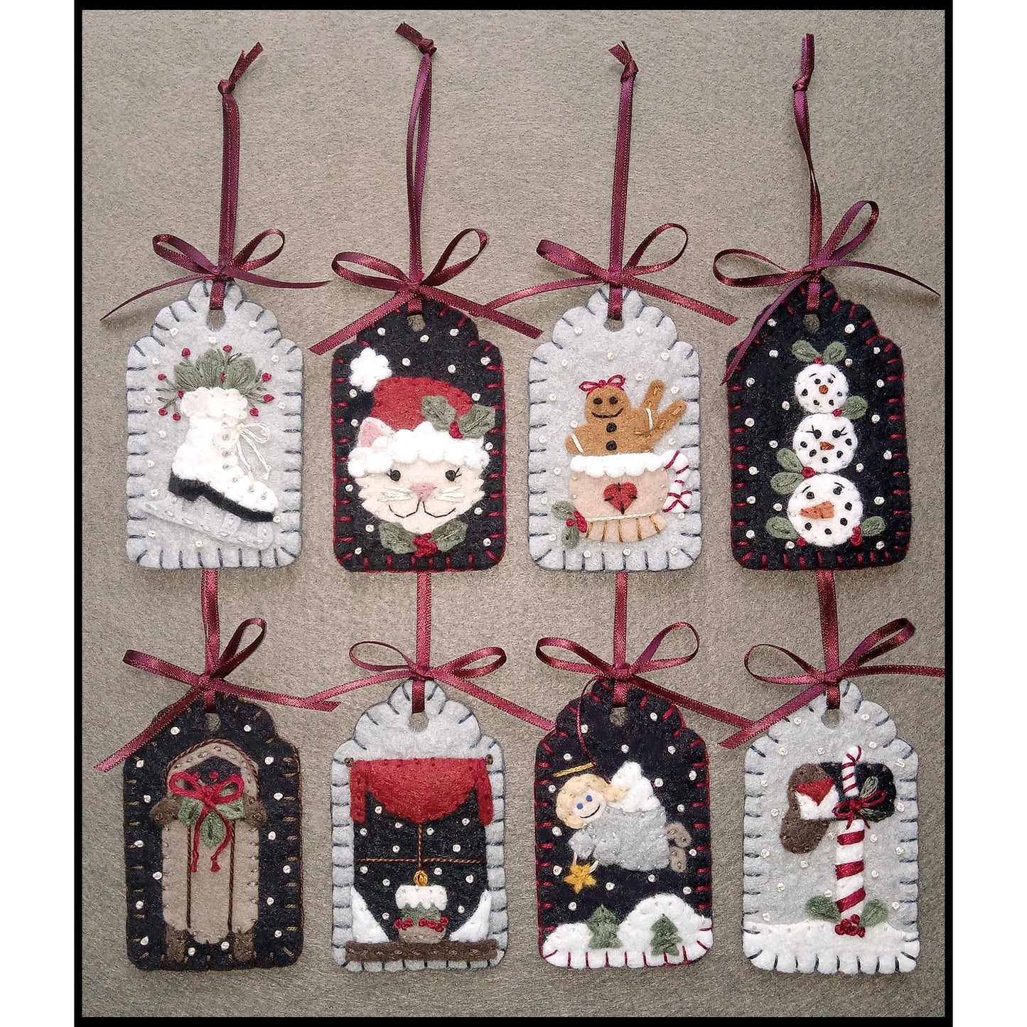 8 adorable gift tags with applique wool designs including an ice skate, Santa cat, gingerbread man in a mug, snowmen face snowballs, sled, window with snow outside and a candle inside, angle over a snowy landscape, and a mailbox with letter and candycane.