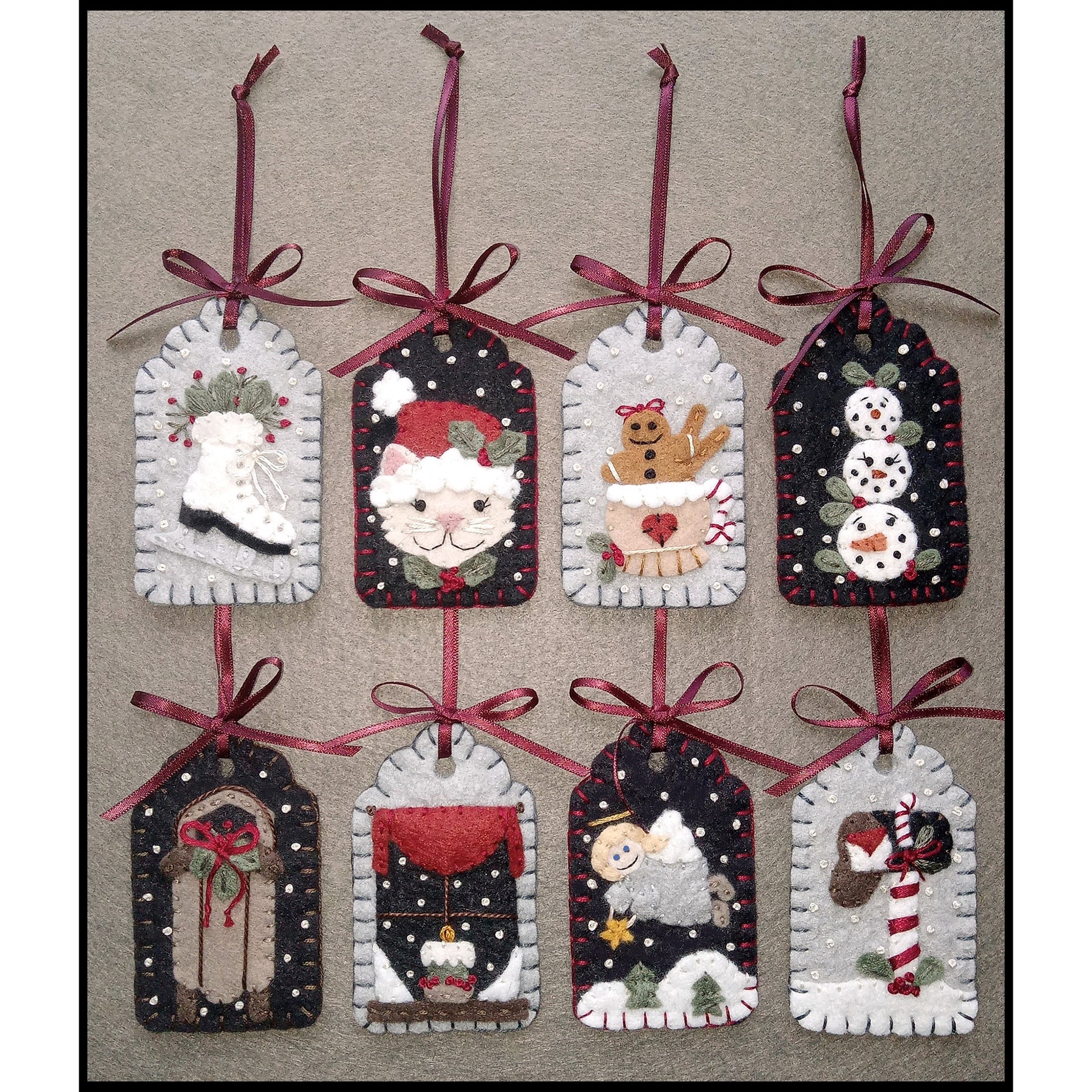 8 adorable gift tags with applique wool designs including an ice skate, Santa cat, gingerbread man in a mug, snowmen face snowballs, sled, window with snow outside and a candle inside, angle over a snowy landscape, and a mailbox with letter and candycane.