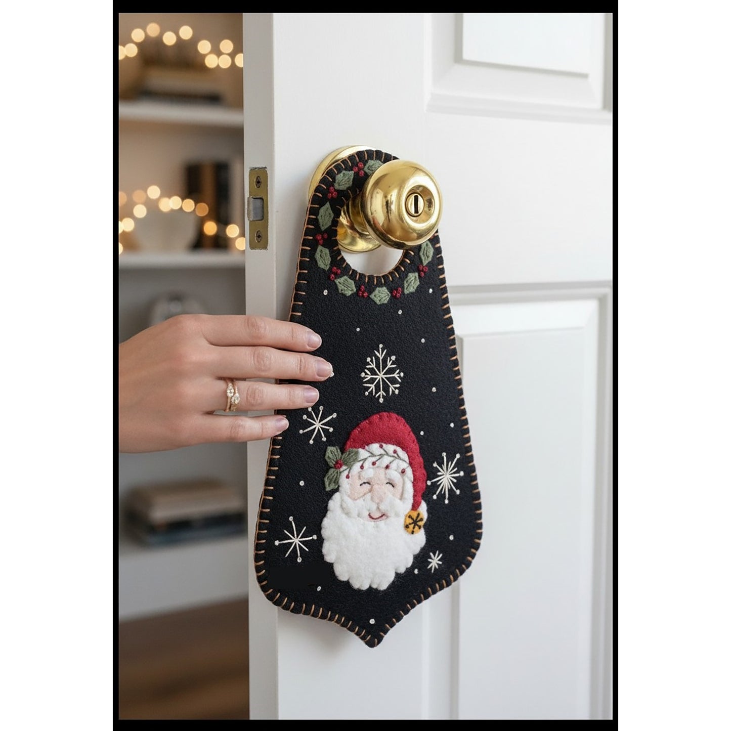This sweet wool door hanger features a smiling Santa surrounded by winter greenery, berries, and pretty snowflakes. 