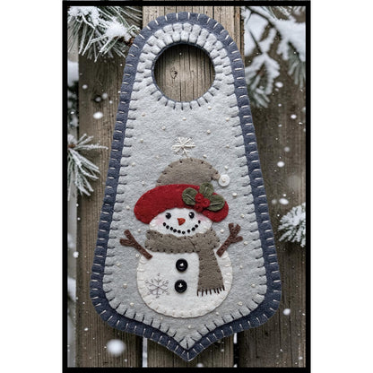 Welcome the first snowfall of the season with this happy little snowman Doorknob hanger. Snowman is wearing a hat and scarf with buttons on his chest.