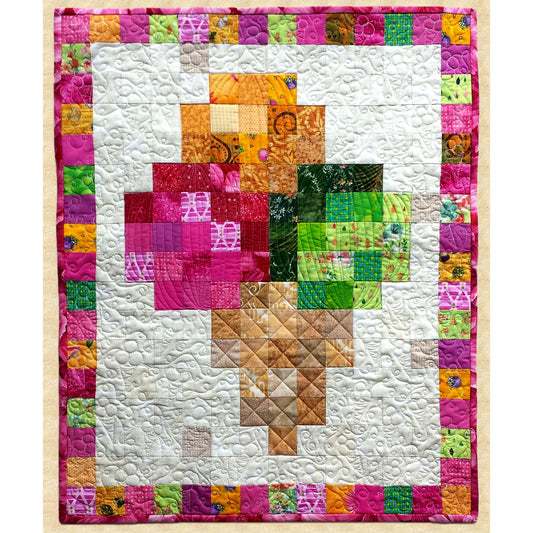 Colorful quilt with a geometric ice cream cone pattern on a white background by Pumpkin Patch Patterns. 
