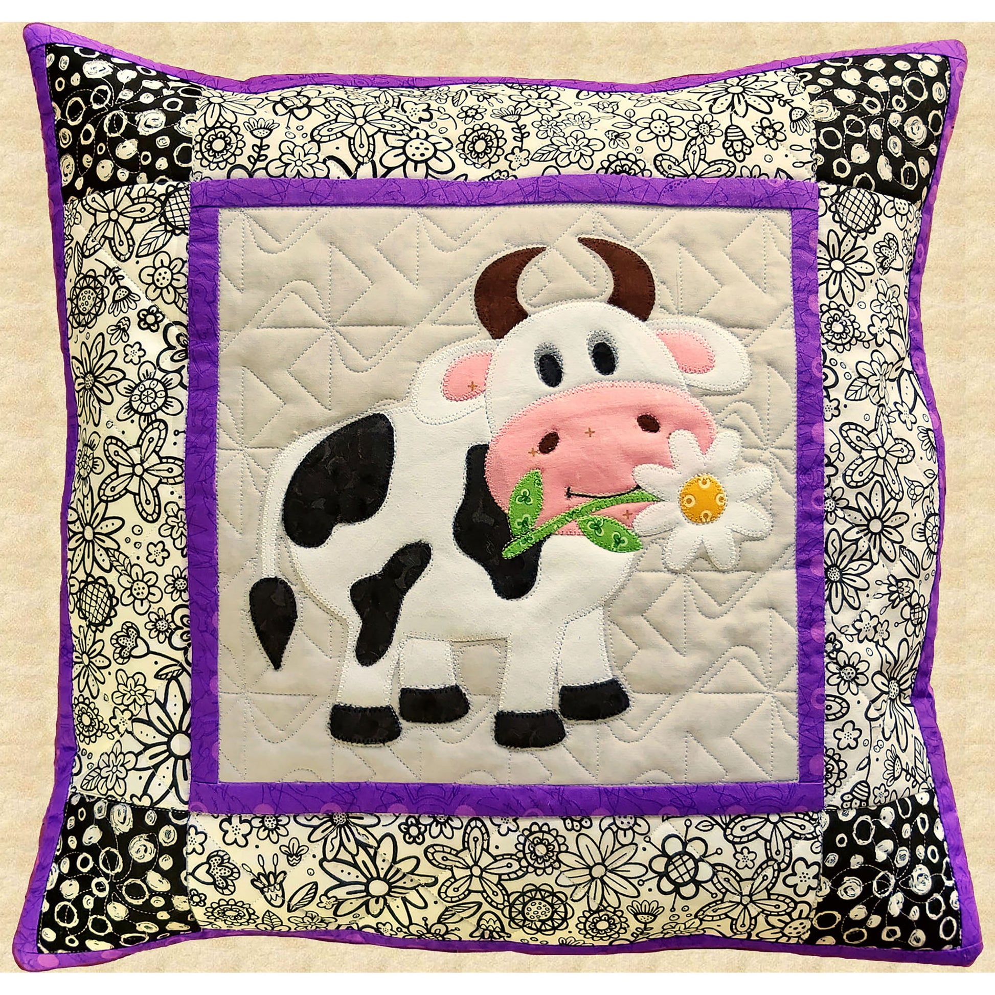 Adorable cow pillow features a full-sized cow with horse and daisy in it's mouth. Purple accent thin border before black and white flower fabric and then finished with purple trim for pillow.