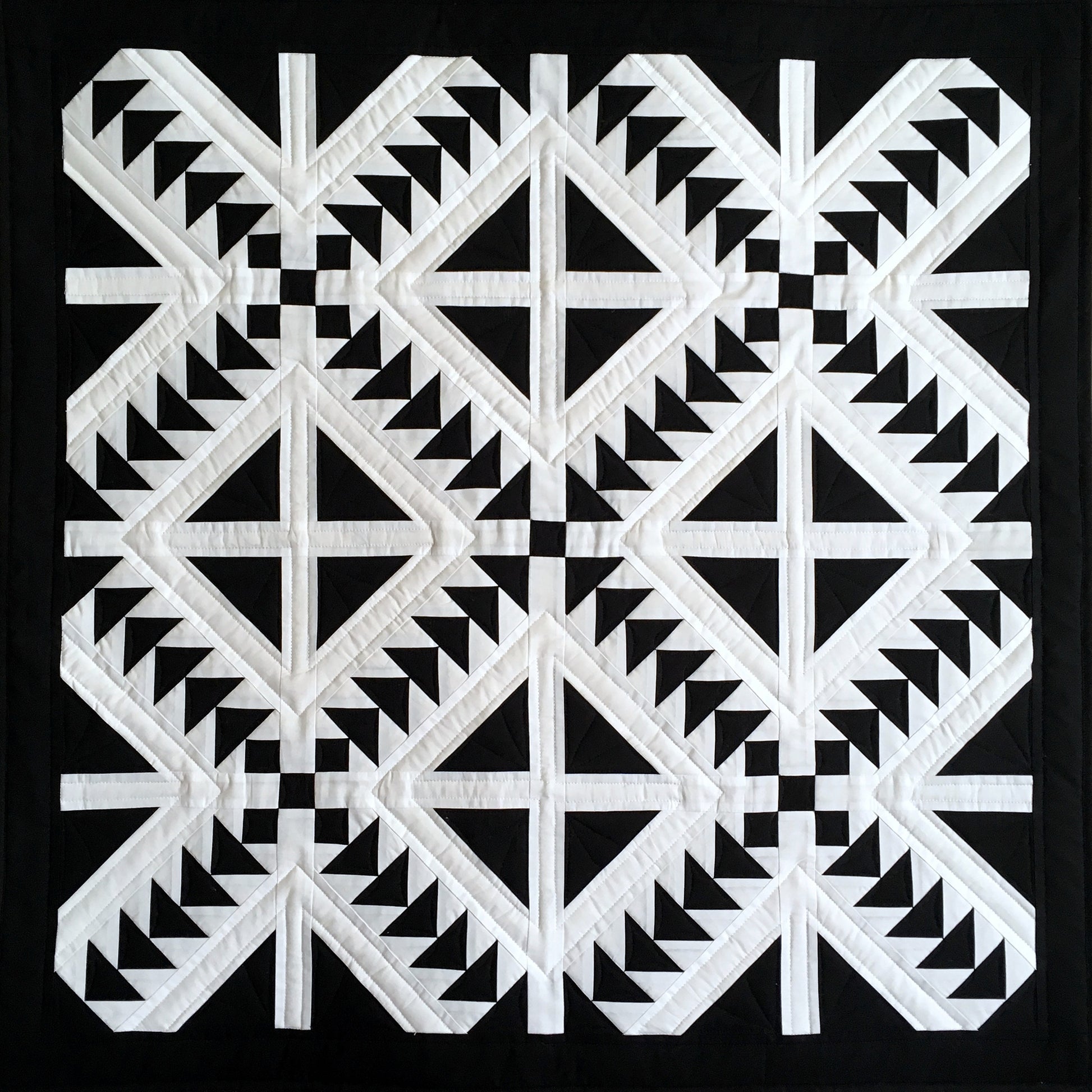 Cross Flight quilt is a quilt in black and white with diamonds cut into four and flying geese blocks.