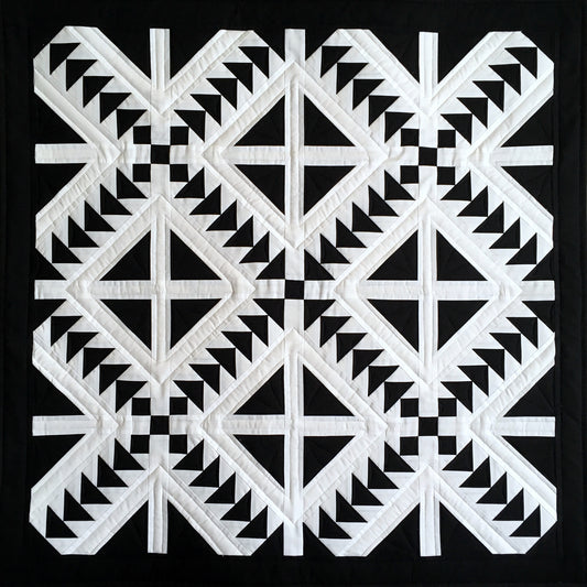 Cross Flight quilt is a quilt in black and white with diamonds cut into four and flying geese blocks.