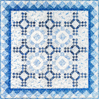 A blue and white quilt featuring a classic square design which looks like maybe snowflakes.