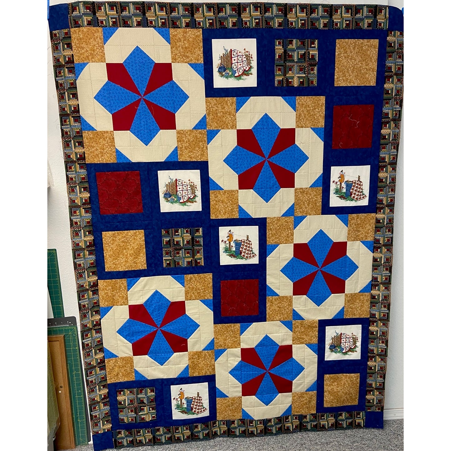 Beautiful quilt featuring large blocks of stars in blue, red, and cream and additional blocks with images and brown.