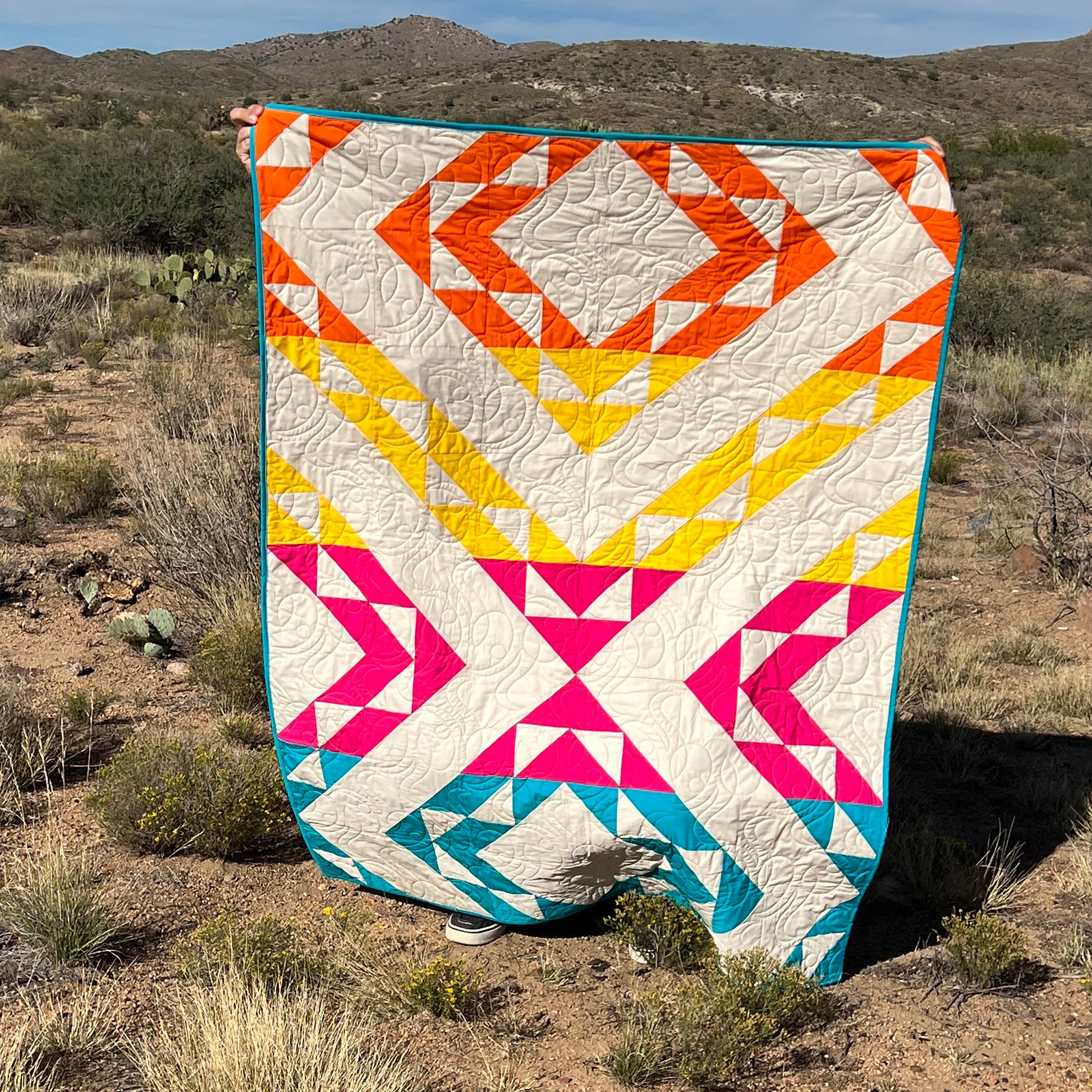 The Fading Day quilt is a modern design inspired by the tranquil transition of daylight into twilight. This modern quilt captures the essence of a sunset's gentle fade with its soft gradient hues and contemporary geometric layout. 