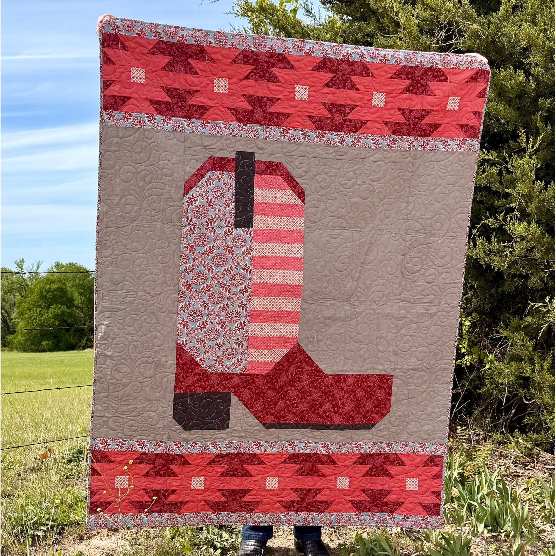 The Heartland Boot quilt is a reflection of our roots that are deep in the Heartland of America. Designed for all the farmers, ranchers and a life tied directly to the land. This quilt is in shades of pink.
