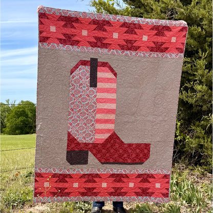 The Heartland Boot quilt is a reflection of our roots that are deep in the Heartland of America. Designed for all the farmers, ranchers and a life tied directly to the land. This quilt is in shades of pink.