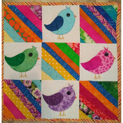 Four adorable and colorful birds on this quilt with interchanging blocks of colorful stripes.
