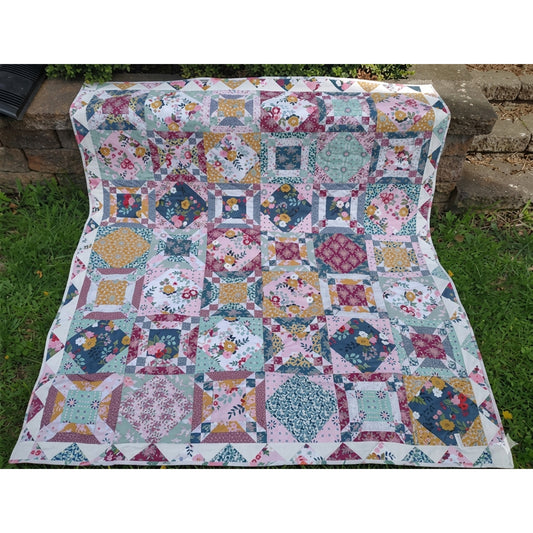 Colorful patchwork quilt on a grassy outdoor setting